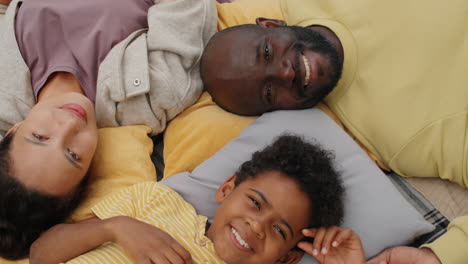 Glückliche-Afroamerikanische-Familie,-Die-Draußen-Auf-Einer-Decke-Liegt-Und-In-Die-Kamera-Lächelt
